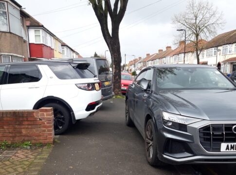 Cars parked on pavement and sticking out into pavement